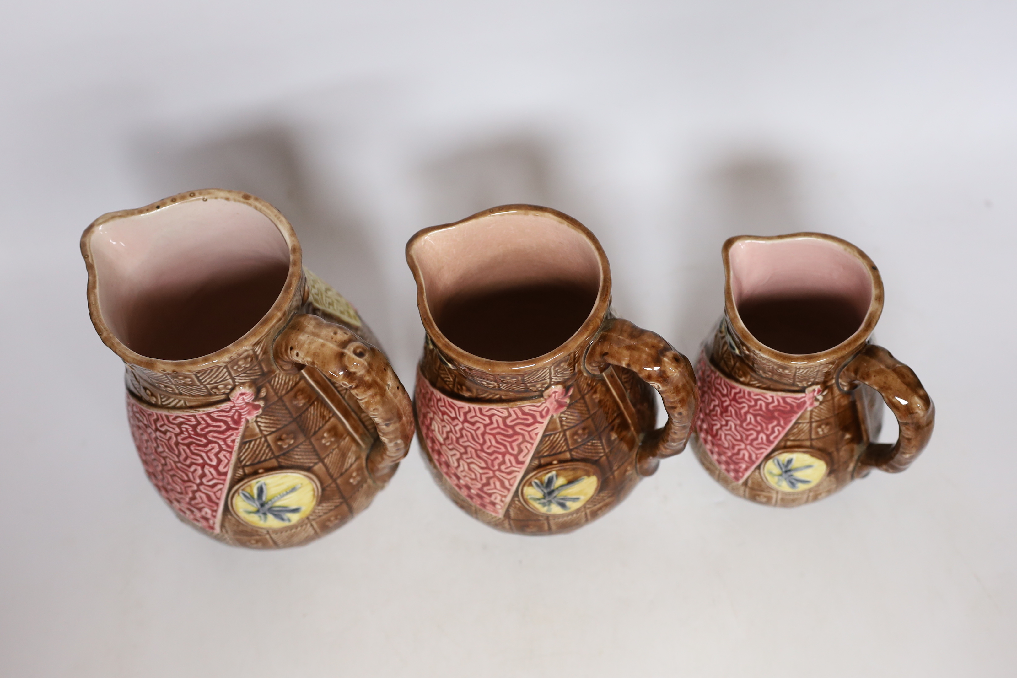 A set of three Aesthetic period graduated majolica jugs, tallest 19.5cm
